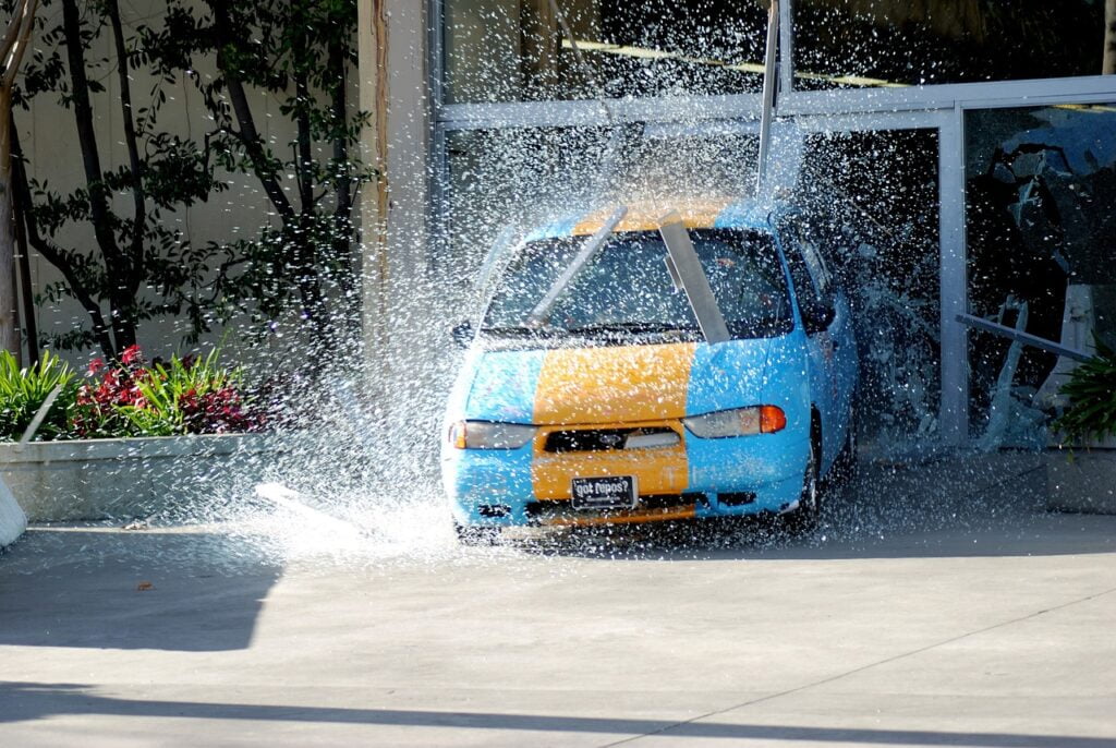 car crashing out of a building